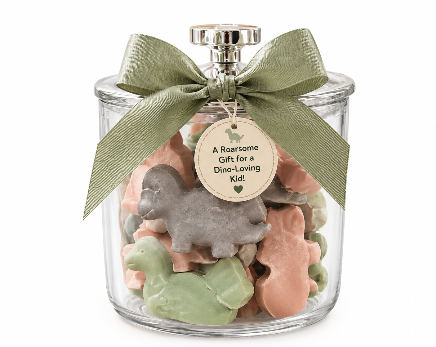 Dinosaur-shaped goat milk soaps in a keepsake glass jar with sage green bow and A Roarsome Gift for a Dino-Loving Kid tag