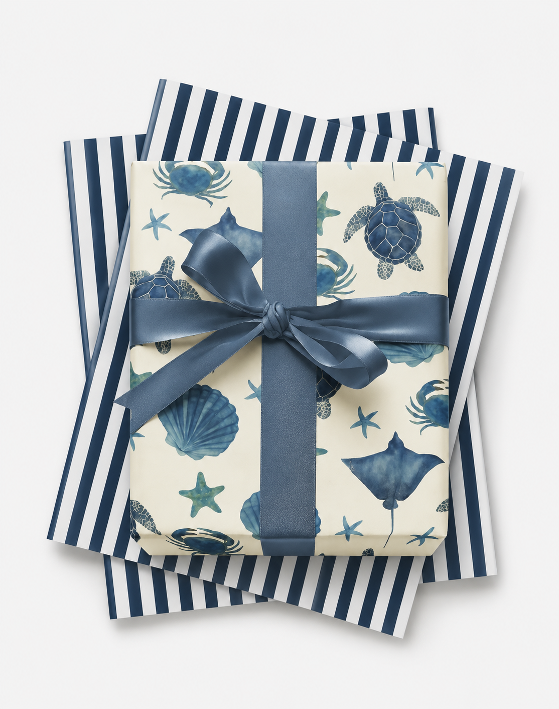Sea life wrapping paper with turtles, crabs, and shells in navy with matching ribbon and striped tissue
